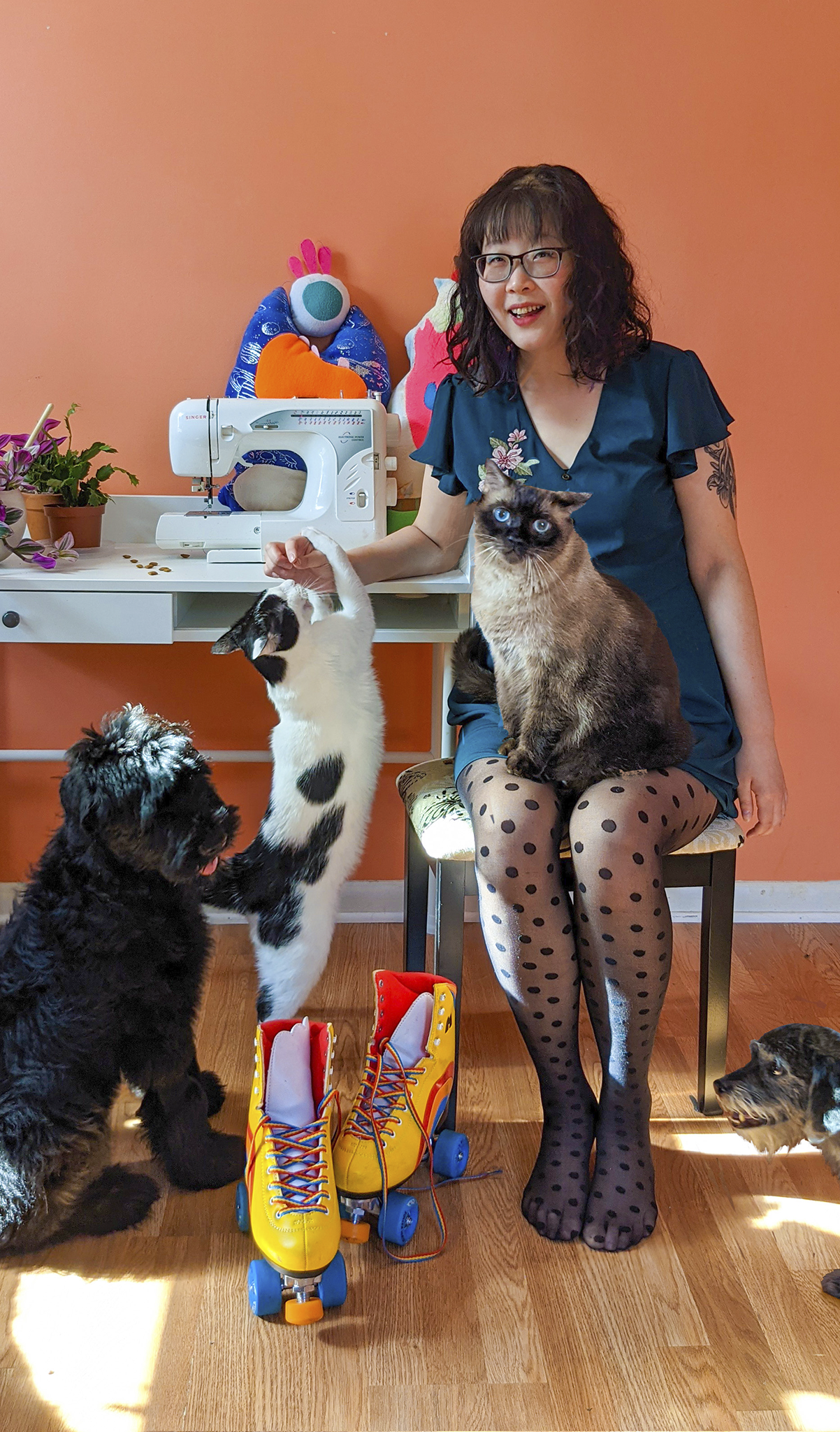 Hanna Lee at sewing machine with two cats and a dog